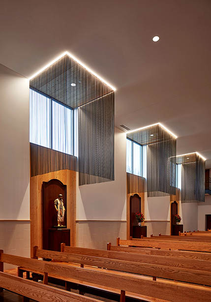 Side chapels to various saints are created with lighting, wood paneling, and wire mesh curtains. Photo: Tom Harris