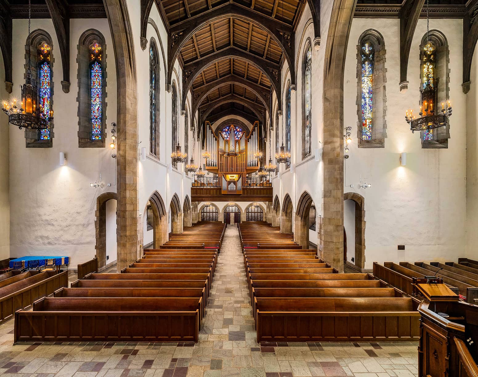 Inside of church showing narrow sides leading up to alter and organ pipes
